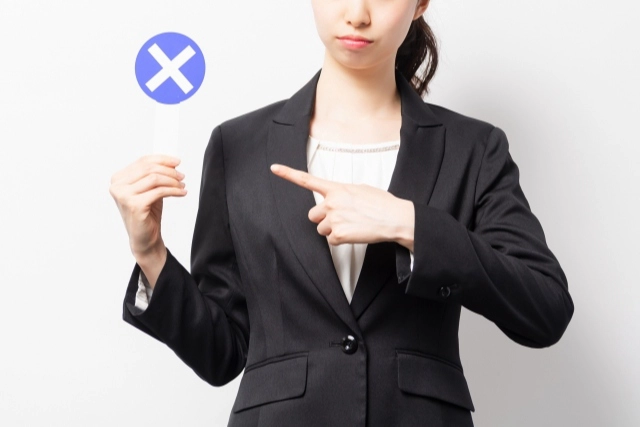 バツのプラカードを持った女性